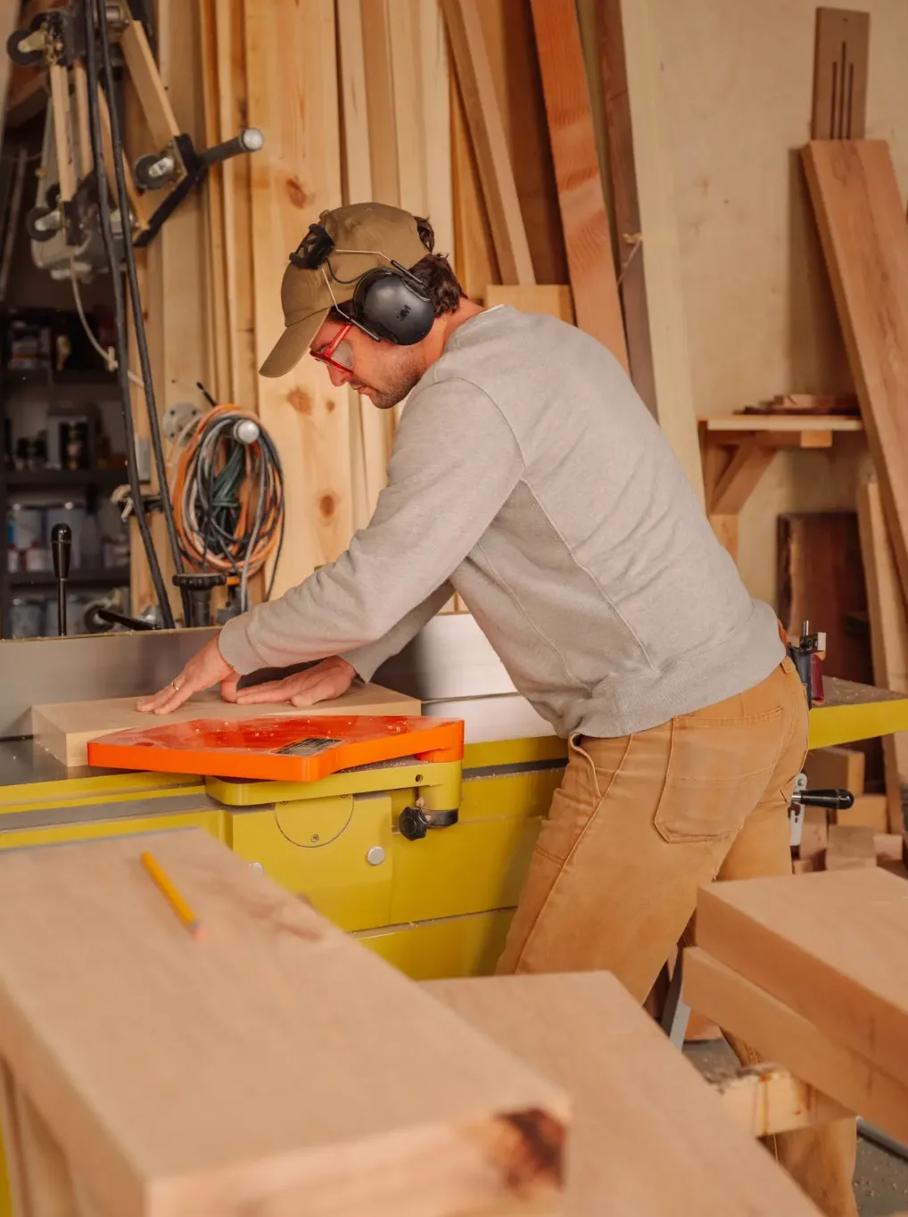 Woodworker running a board through a jointer in his shop