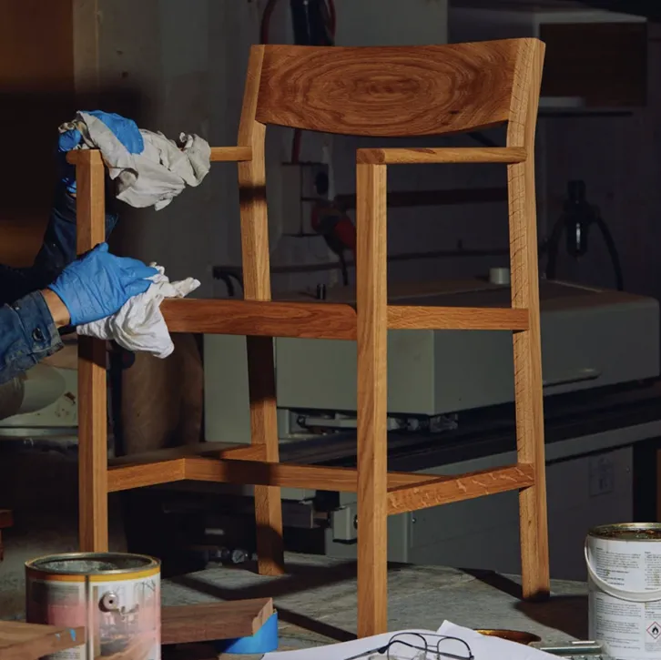 Craftsman finishing wooden furniture in workshop
